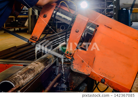 orange colored industrial cutting machine in working processed doing cutting a steel pipe in factory orange colored industrial cutting machine in working processed doing cutting a steel pipe in factory 142367085