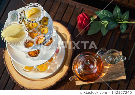 a tower of desserts served with a jar of tea on the table waiting for customers in riverside restaurant 142367240