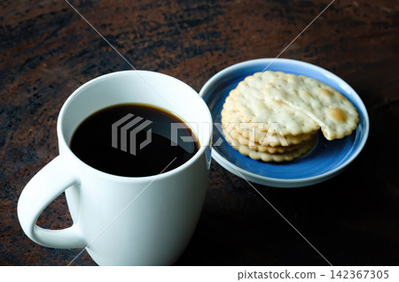 black hot coffee served with wheat crackers on dark wooden table black hot coffee served with wheat crackers on dark wooden table 142367305