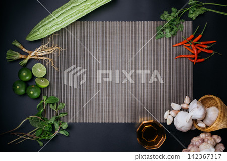 a empty food preparing space of textured napery on black table surrounding by ingredient 142367317