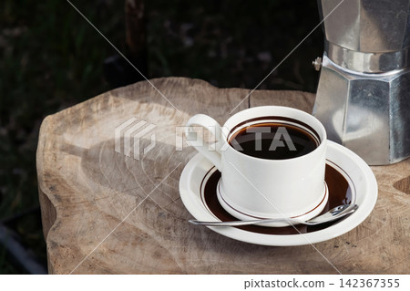 black coffee brewed by moka pot on wood table in sunshine at the morning 142367355