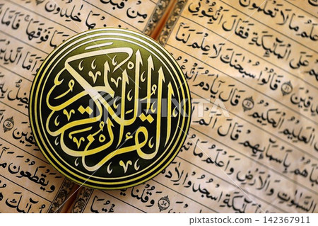 Sign with Al Quran inscription on Muslim holy book in mosque. Details of arabic calligraphy 142367911