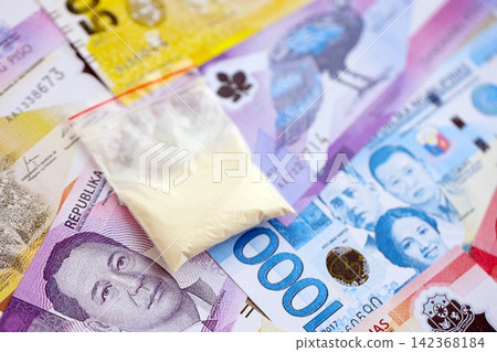 Philippines peso currency money bills and cocaine pack. The concept of drug trafficking 142368184