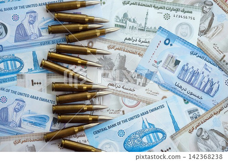 United Arab Emirates dirham currency money bills and rifle bullets. The concept of warfare and gun selling United Arab Emirates dirham currency money bills and rifle bullets. The concept of warfare and gun selling 142368238