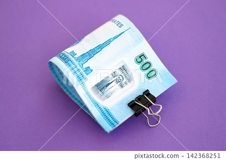United Arab Emirates dirham money bills in big amount on purple. Finance and banking concept United Arab Emirates dirham money bills in big amount on purple. Finance and banking concept 142368251