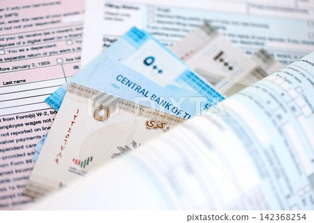 United Arab Emirates dirham money bills on tax form. Taxation and accounting concept United Arab Emirates dirham money bills on tax form. Taxation and accounting concept 142368254
