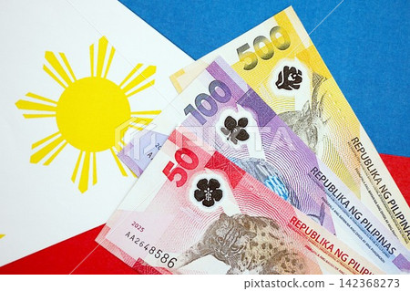 Philippines peso currency money bills lies on flag. The concept of business and investment Philippines peso currency money bills lies on flag. The concept of business and investment 142368273