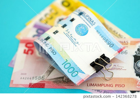 Philippines peso money bills in big amount on blue. Finance and banking concept 142368278