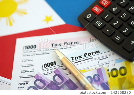 Philippines peso money bills and calculator with tax form on flag. Taxation and accounting concept Philippines peso money bills and calculator with tax form on flag. Taxation and accounting concept 142368280