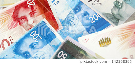 Israel New Shekels banknotes. The current Israel money bills lies on table in big amount Israel New Shekels banknotes. The current Israel money bills lies on table in big amount 142368395