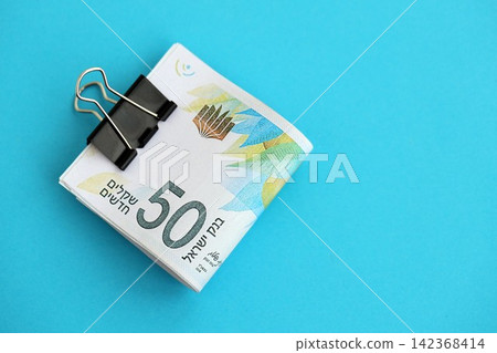 Israel New Shekels banknotes on blue background. The current Israel money bills lies on blue 142368414