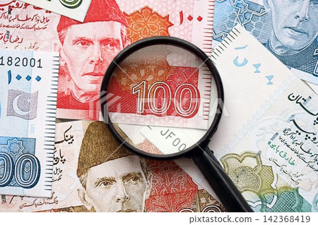 Pakistan rupees banknotes and magnifying glass. The current Pakistan money bills with loupe Pakistan rupees banknotes and magnifying glass. The current Pakistan money bills with loupe 142368419