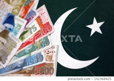 Pakistan rupees banknotes on Pakistani flag background. The current Pakistan money bills Pakistan rupees banknotes on Pakistani flag background. The current Pakistan money bills 142368425