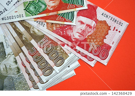 Pakistan rupees banknotes on red background. The current Pakistan money bills Pakistan rupees banknotes on red background. The current Pakistan money bills 142368429