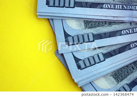 Big amount of United States hundred dollar bills on yellow background Big amount of United States hundred dollar bills on yellow background 142368474