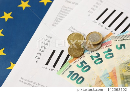 European union Euro money bills and coins with european electricity utility bill on table European union Euro money bills and coins with european electricity utility bill on table 142368502