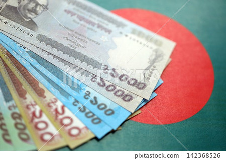 Bangladeshi taka money bills in big amount lies on Bangladesh flag close up Bangladeshi taka money bills in big amount lies on Bangladesh flag close up 142368526