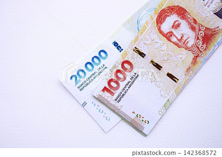 Argentine pesos money bills in big amount lies on white table close up 142368572