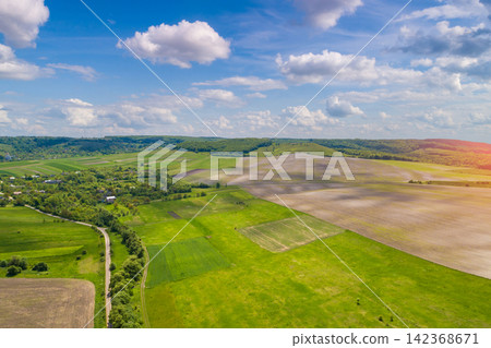 Rural landscape. Aerial view. View of highway and plowed and green fields in spring Rural landscape. Aerial view. View of highway and plowed and green fields in spring 142368671