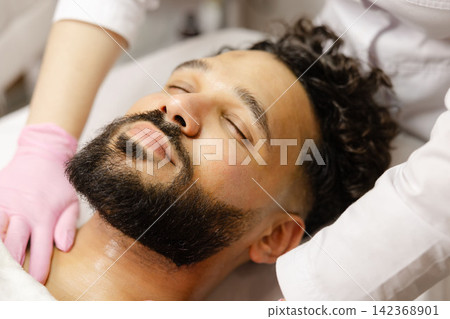 Man receiving professional facial spa treatment Man receiving professional facial spa treatment 142368901