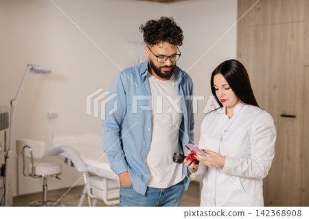 Dermatologist checking patient skin with a dermatoscope Dermatologist checking patient skin with a dermatoscope 142368908