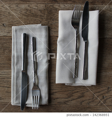 Vintage handmade napkins for forks and knives on antique table muted colors stock photo Vintage handmade napkins for forks and knives on antique table muted colors stock photo 142368931