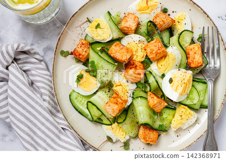 Delicious salmon and egg salad served on a plate with fresh cucumber and herbs for a healthy meal at lunchtime Delicious salmon and egg salad served on a plate with fresh cucumber and herbs for a healthy meal at lunchtime 142368971