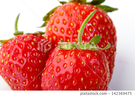 beautiful and ripe red strawberries on a white background beautiful and ripe red strawberries on a white background 142369475