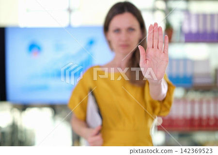 Serious businesswoman raises Stop hand during office presentation Serious businesswoman raises Stop hand during office presentation 142369523
