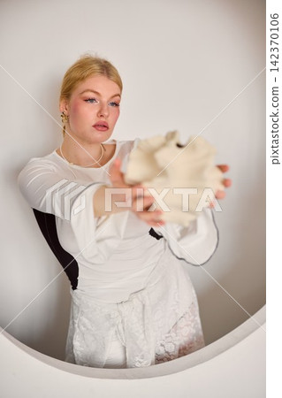 Portrait of woman presenting textured ceramic piece in studio setting Portrait of woman presenting textured ceramic piece in studio setting 142370106