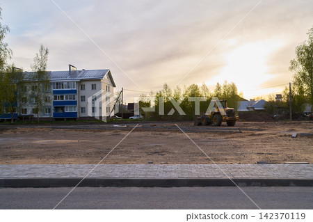 Calm sunset scene showing earthmoving vehicles and soft shadows Calm sunset scene showing earthmoving vehicles and soft shadows 142370119