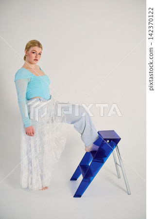 Woman wearing blue demonstrates assertive stance and stylish motion Woman wearing blue demonstrates assertive stance and stylish motion 142370122
