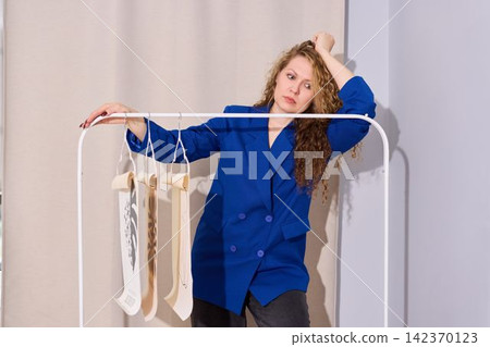 Caucasian woman carefully inspects garment sketches and fabric samples Caucasian woman carefully inspects garment sketches and fabric samples 142370123