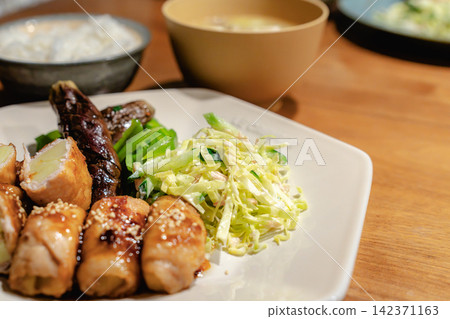 A Japanese main dish consisting of pork rolls, eggplant, and cabbage salad. A Japanese main dish consisting of pork rolls, eggplant, and cabbage salad. 142371163