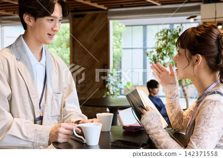 男男女女在咖啡館一邊喝咖啡一邊聊天。 男男女女在咖啡館一邊喝咖啡一邊聊天。 142371558