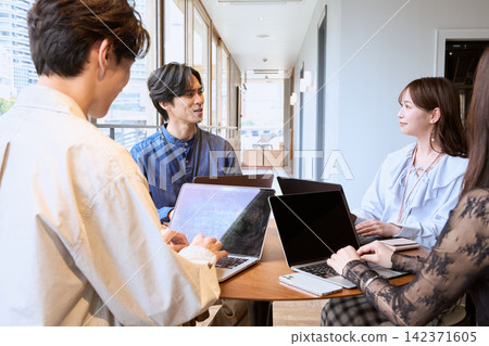一位年輕的商務人士正在辦公室的共享空間裡用筆記型電腦開會。 一位年輕的商務人士正在辦公室的共享空間裡用筆記型電腦開會。 142371605