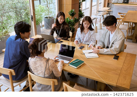 Five young business people having a meeting in a cafe-style office. Five young business people having a meeting in a cafe-style office. 142371625