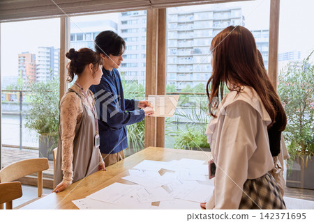 商務人士在辦公室開會並展示文件。 商務人士在辦公室開會並展示文件。 142371695