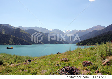 Turquoise Alpine Lake with Mountain Valley and Wildflower Meadow Turquoise Alpine Lake with Mountain Valley and Wildflower Meadow 142372069