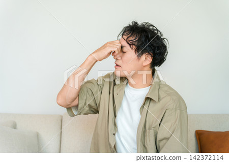 一名疲憊的男子因眼睛疲勞(眼睛疲倦、眼睛乾澀、智慧型手機疲勞)而摀著內眼角。 一名疲憊的男子因眼睛疲勞(眼睛疲倦、眼睛乾澀、智慧型手機疲勞)而摀著內眼角。 142372114