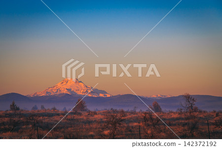Snowy Mountain at Sunset with Wide Blue Sky and Rural Landscape Snowy Mountain at Sunset with Wide Blue Sky and Rural Landscape 142372192