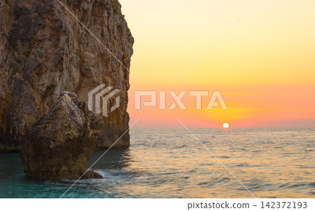 Ocean Sunset with Rocky Sea Cliff and Golden Coastal Horizon Ocean Sunset with Rocky Sea Cliff and Golden Coastal Horizon 142372193