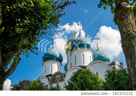 Orthodox Church Blue Onion Domes Framed by Green Trees 142372232