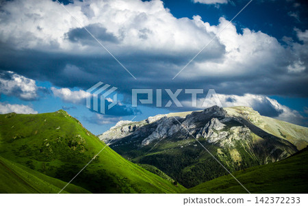 Mountain Landscape with Dramatic Clouds and Green Alpine Hills Mountain Landscape with Dramatic Clouds and Green Alpine Hills 142372233