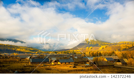 Autumn Mountain Village Under Dramatic Clouds and Golden Forest Autumn Mountain Village Under Dramatic Clouds and Golden Forest 142372246