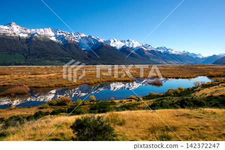 Snowy Mountain Range Reflected in Alpine Lake Landscape Snowy Mountain Range Reflected in Alpine Lake Landscape 142372247