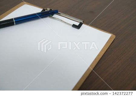 A black pen and a blank sheet of paper A black pen and a blank sheet of paper 142372277