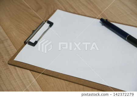 A pen placed on a clipboard A pen placed on a clipboard 142372279