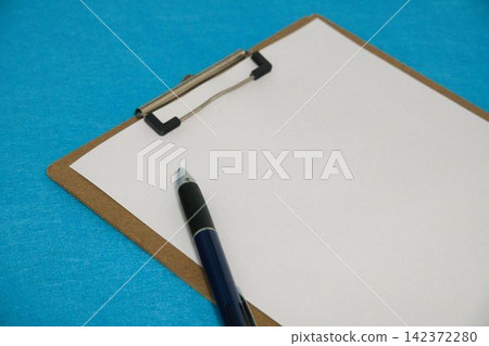 A pen placed on a clipboard A pen placed on a clipboard 142372280