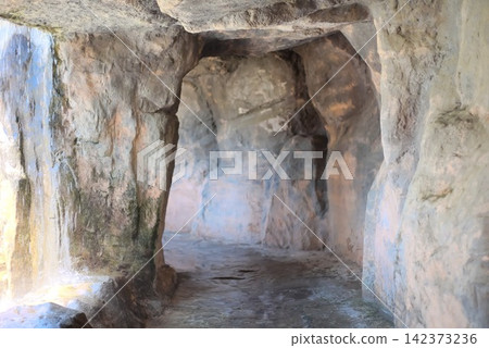 A cave-like passageway mimicking a rocky landscape and a refreshing waterside space reflecting the flowing water. 142373236